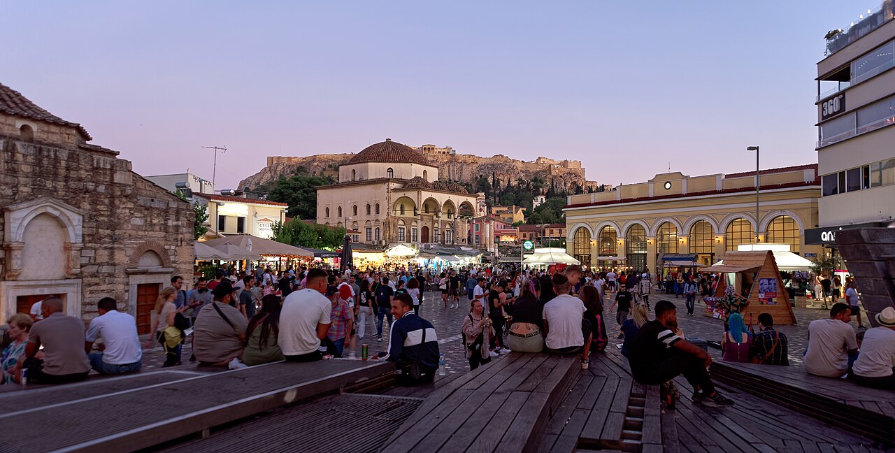 Monastiraki Square in Athens at dusk with the Acropolis rising behind the rooftops
