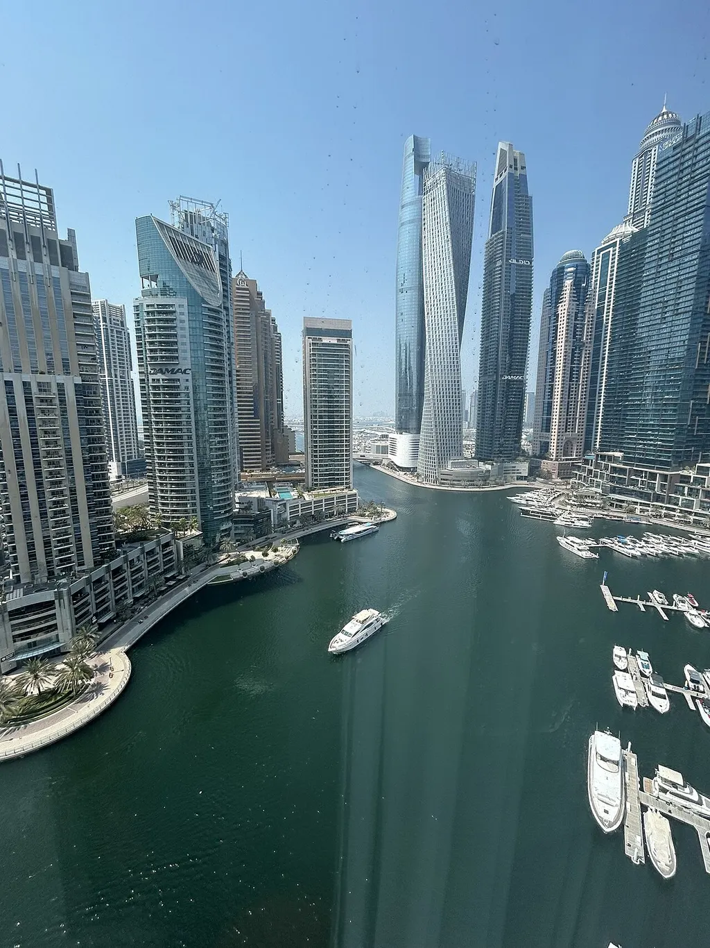 Dubai Marina towers and boats under a clear sky