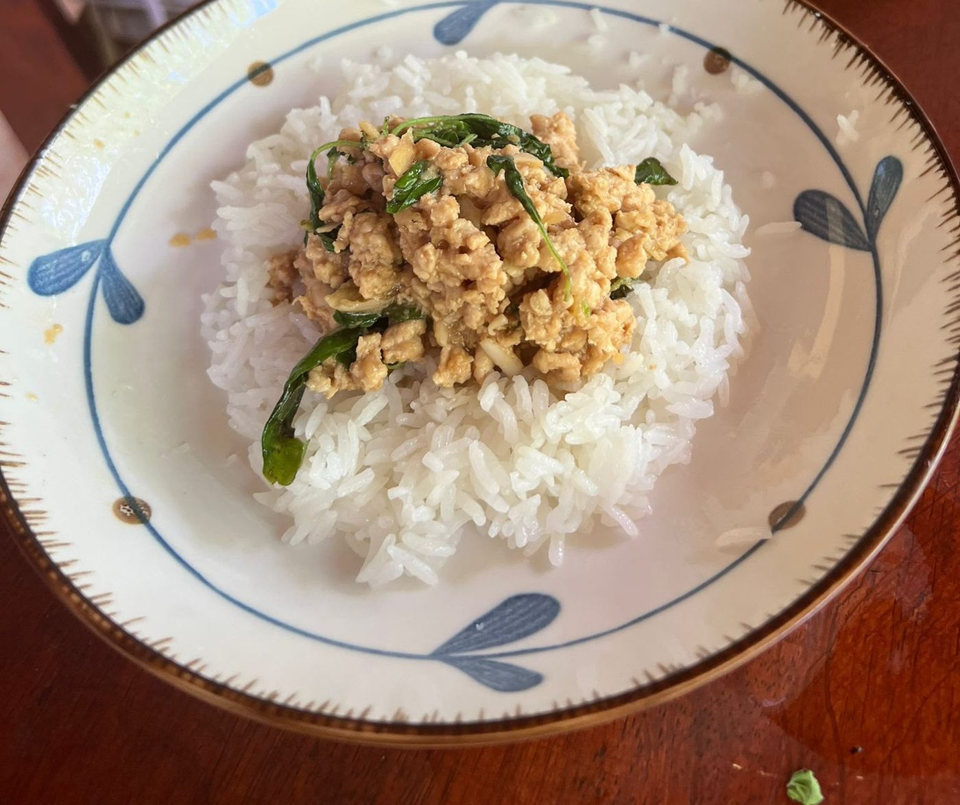 Plato de pollo con albahaca sobre arroz blanco